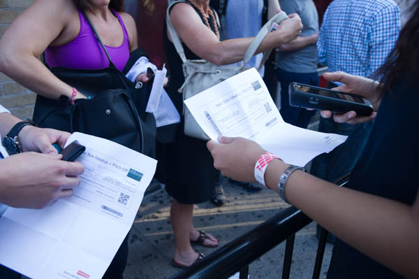 some people are standing around with papers in their hand