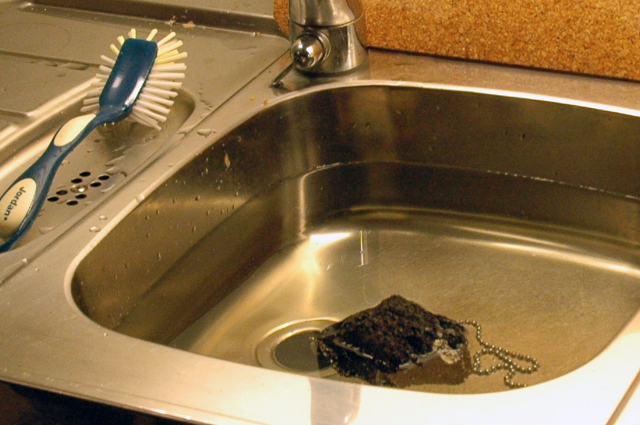 a blue and white toothbrush in a metal sink