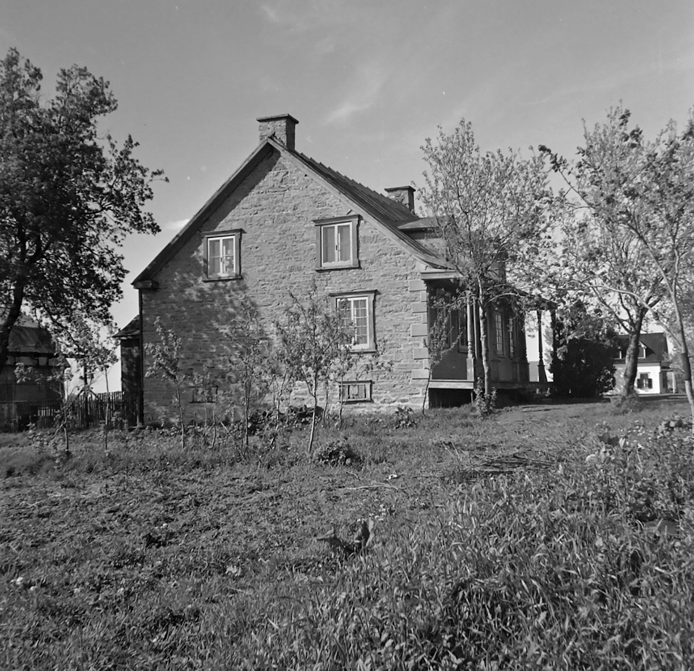 the small house is surrounded by trees in a rural area