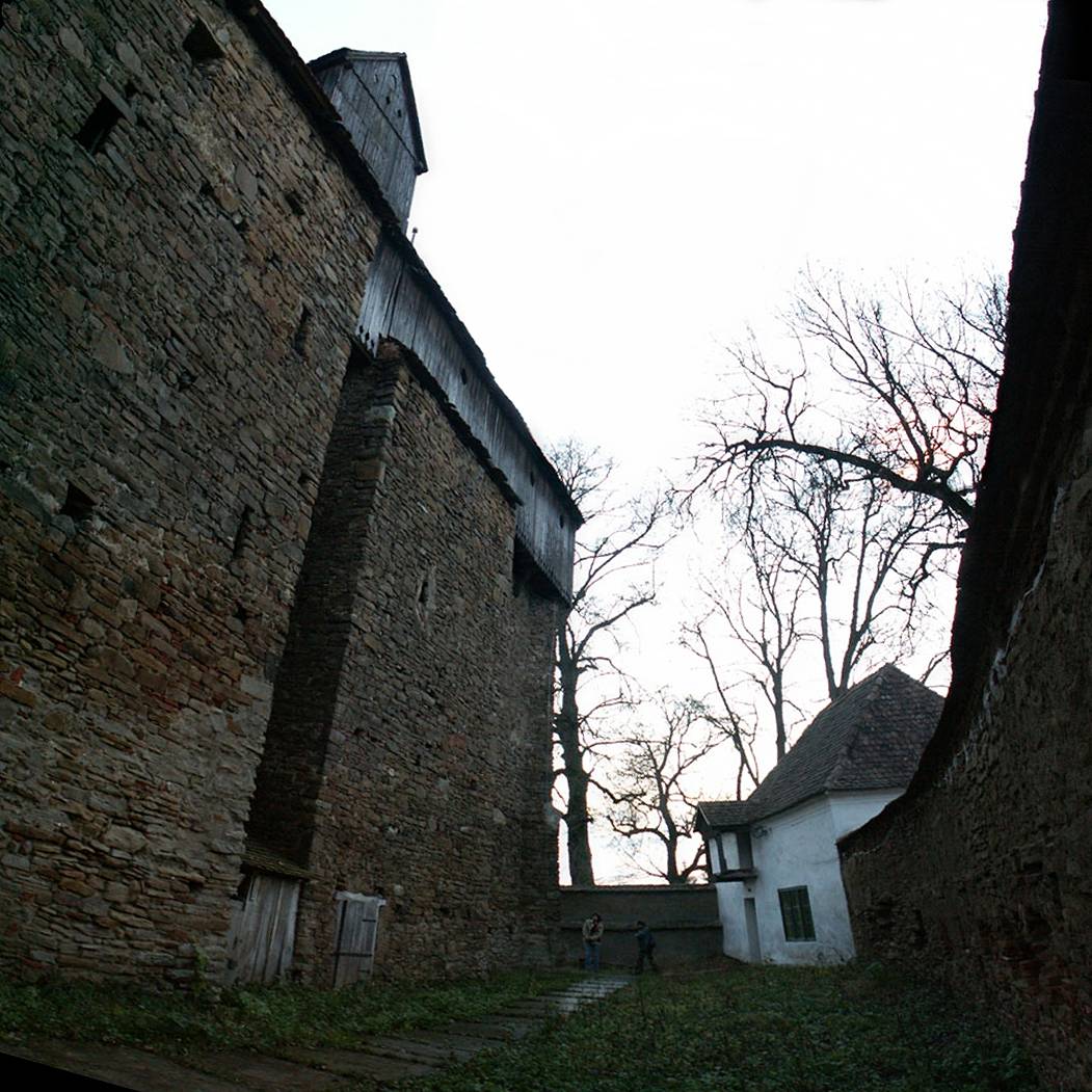 a small white building sitting between two brick walls