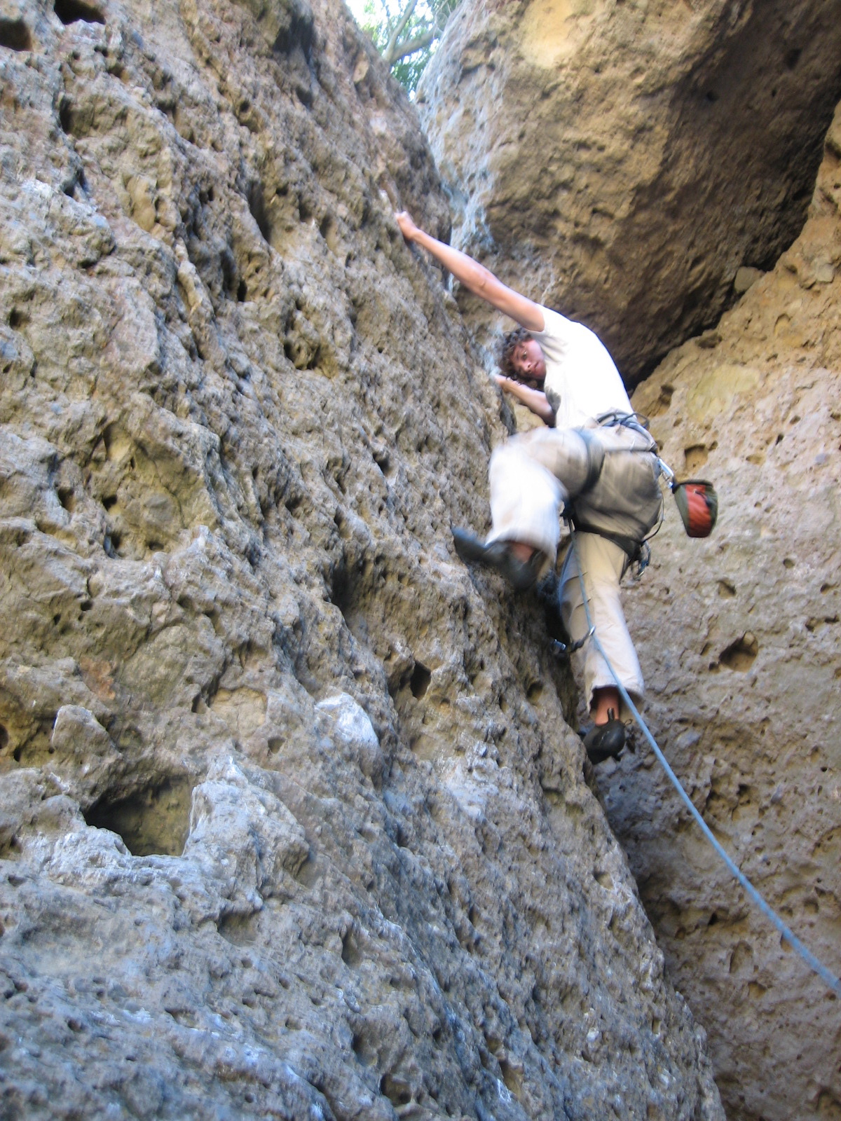 a man climbing a rocky wall with his hands in the air