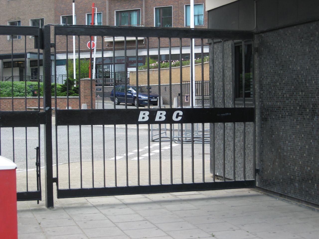 black gate on sidewalk near parking lot in urban setting