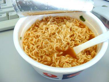 the cup is filled with noodles and broth