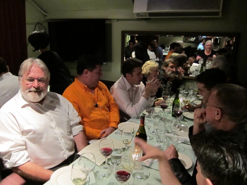 a group of people sitting around a dining table having a meal