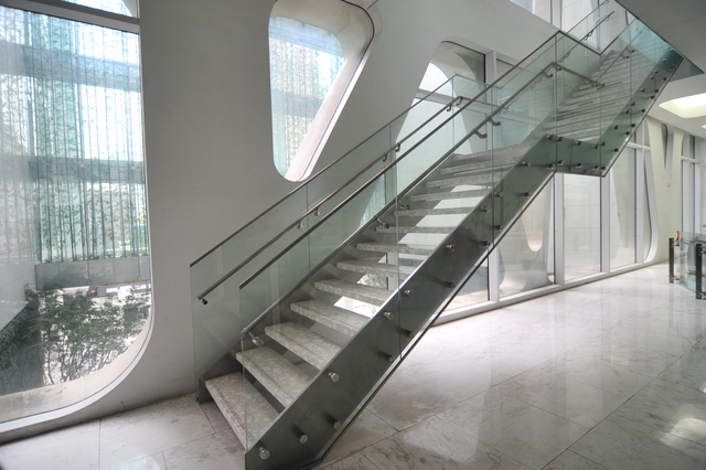 a modern stairs in a building near large window