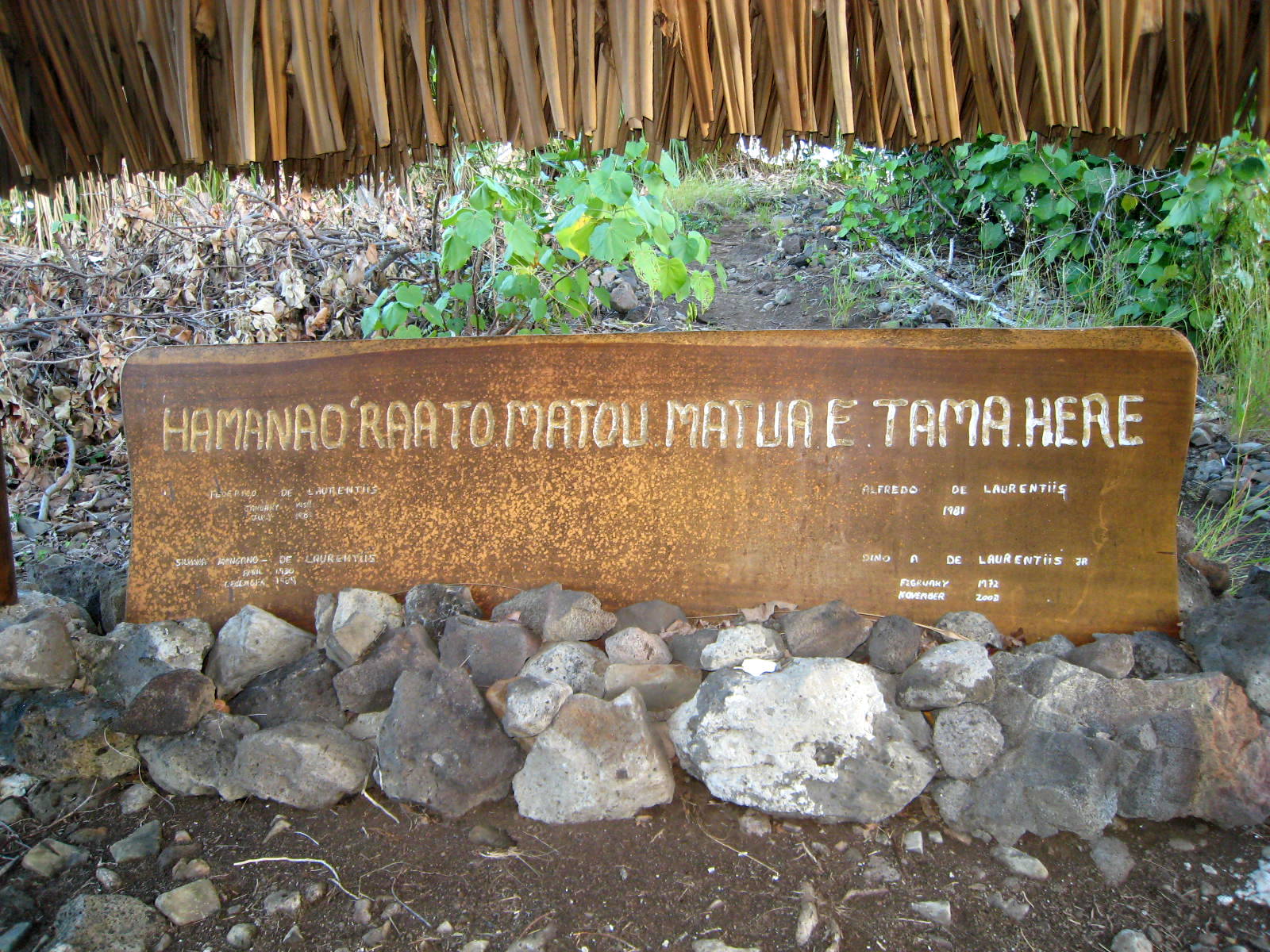 a plaque is set among some rocks and plants
