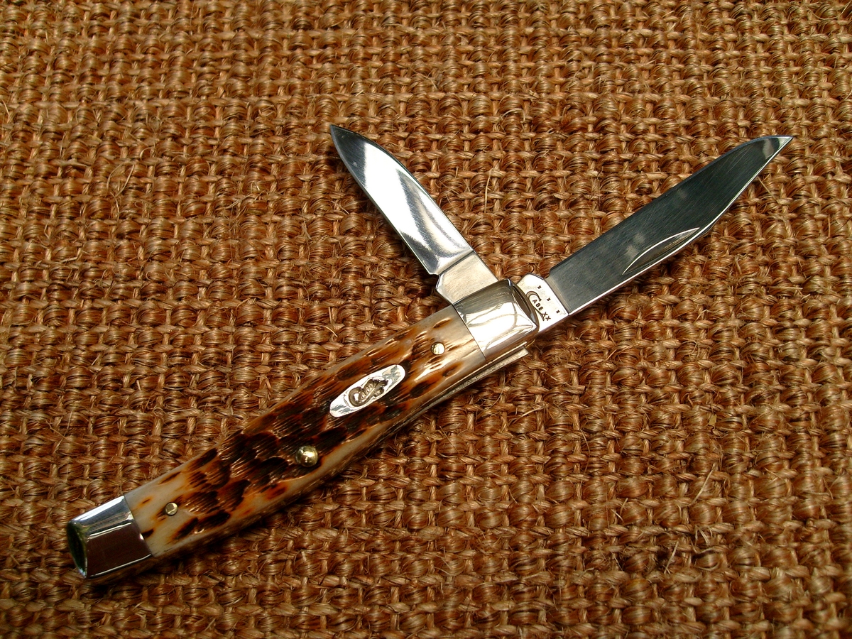 a leopard print pocket knife rests on brown fabric