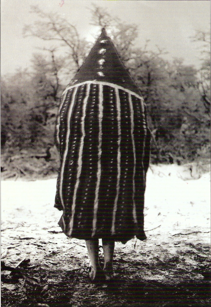 an old po of a man wearing a striped blanket in the snow