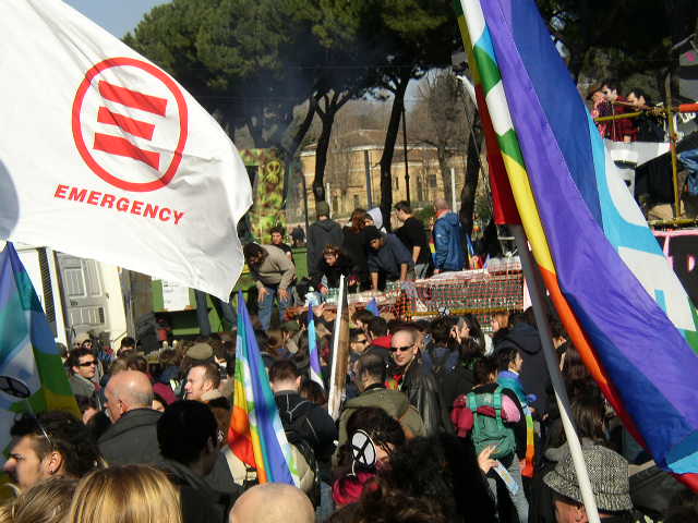 a group of people standing around holding rainbow flags