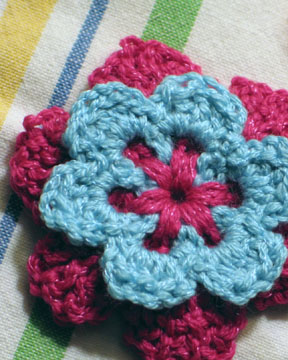 small crocheted flowers on the towel top