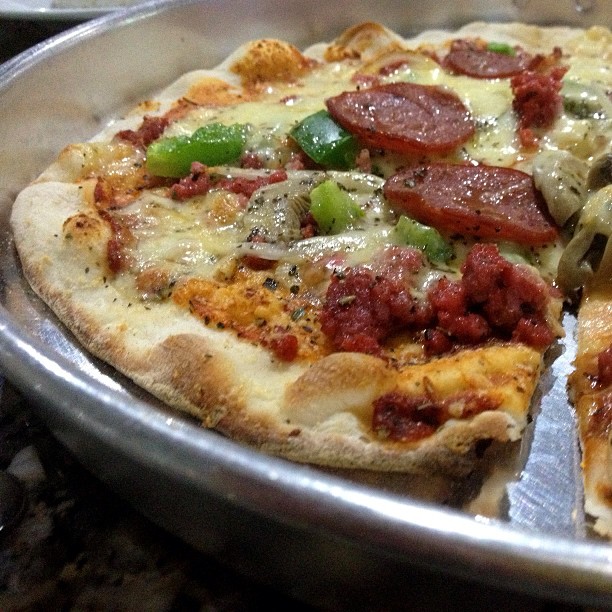 a pizza that is in a silver dish