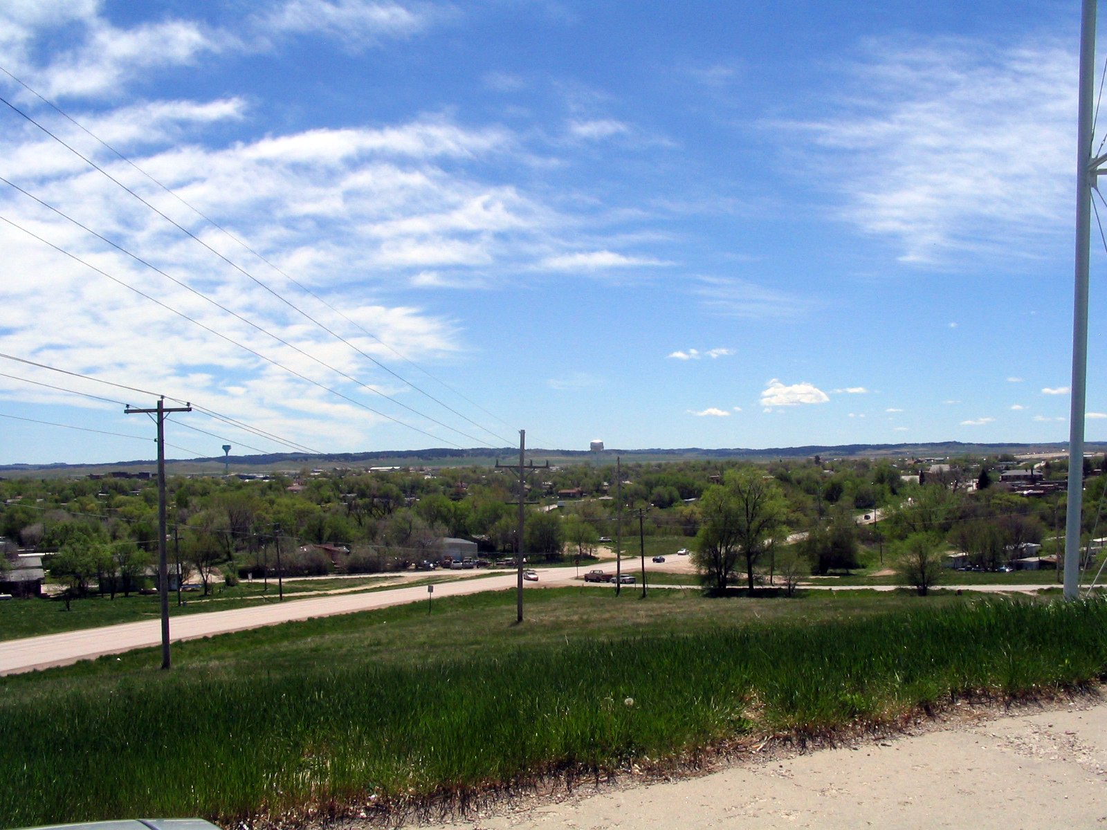 a large grassy field with street lights and power lines