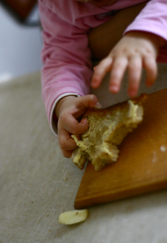 a little girl is peeling an apple slice