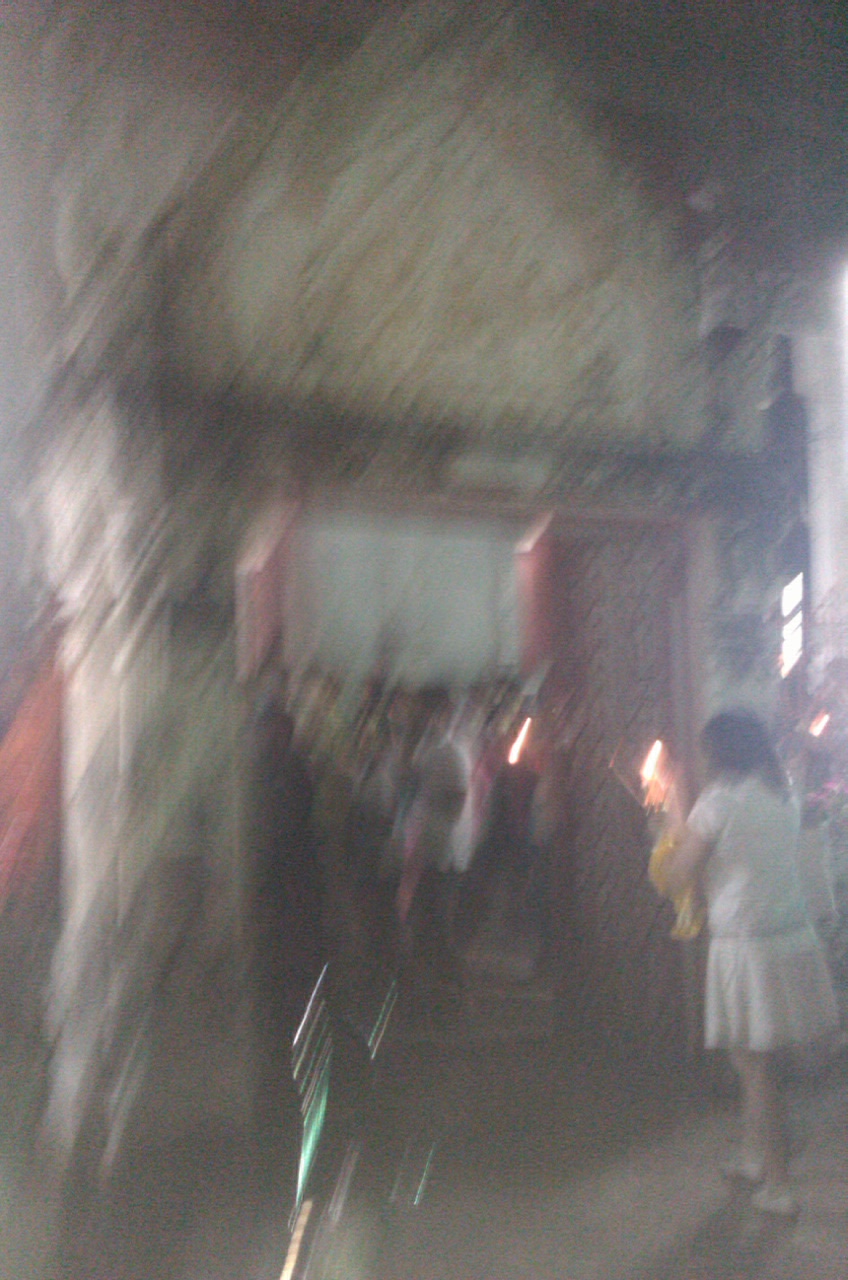 blurry image of people in room with white walls