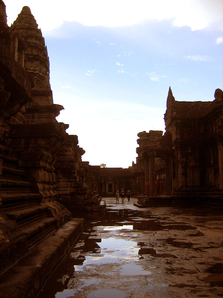 a view from inside an ancient temple with water running down the sidewalk