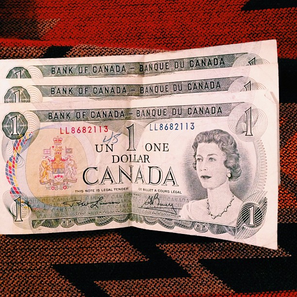 two bills of canadian currency on a patterned background