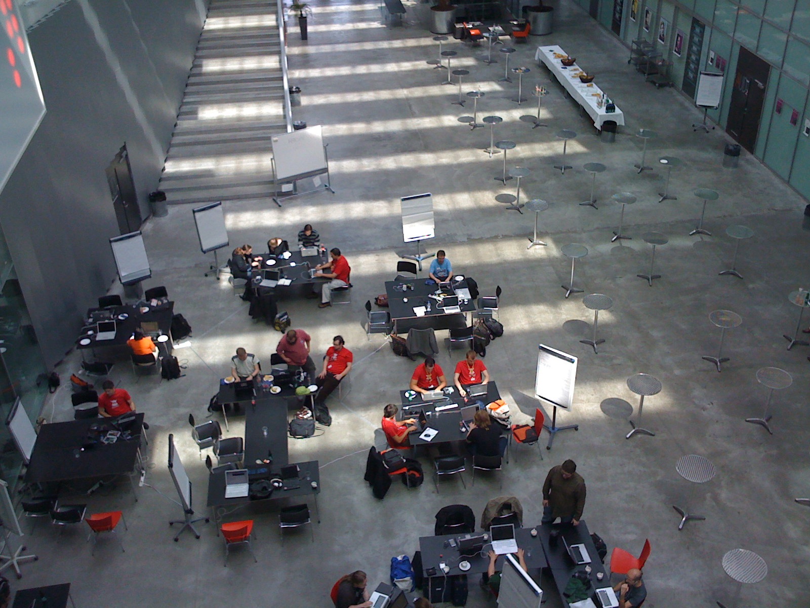 people work and talk at tables in an open area