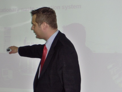 a person giving a presentation on stage wearing a red tie