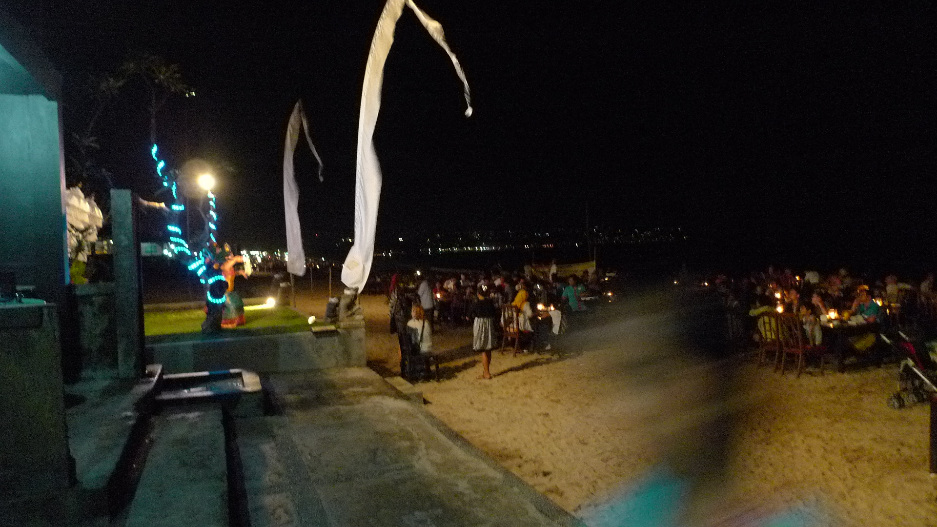 a crowd of people on the beach watching soing flying