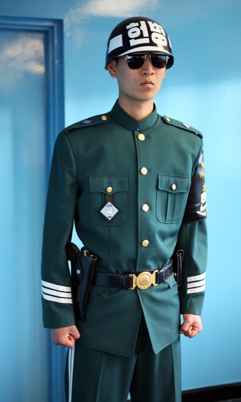 a man wearing a uniform in front of a blue wall