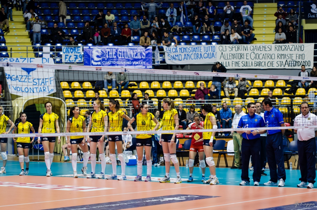 some people are playing volleyball while people watch