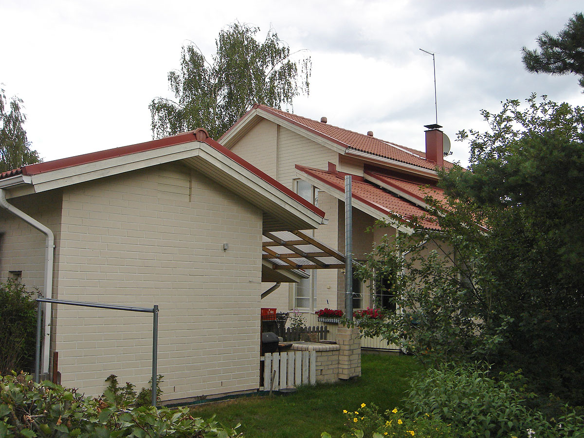 a white and red building with two windows next to trees