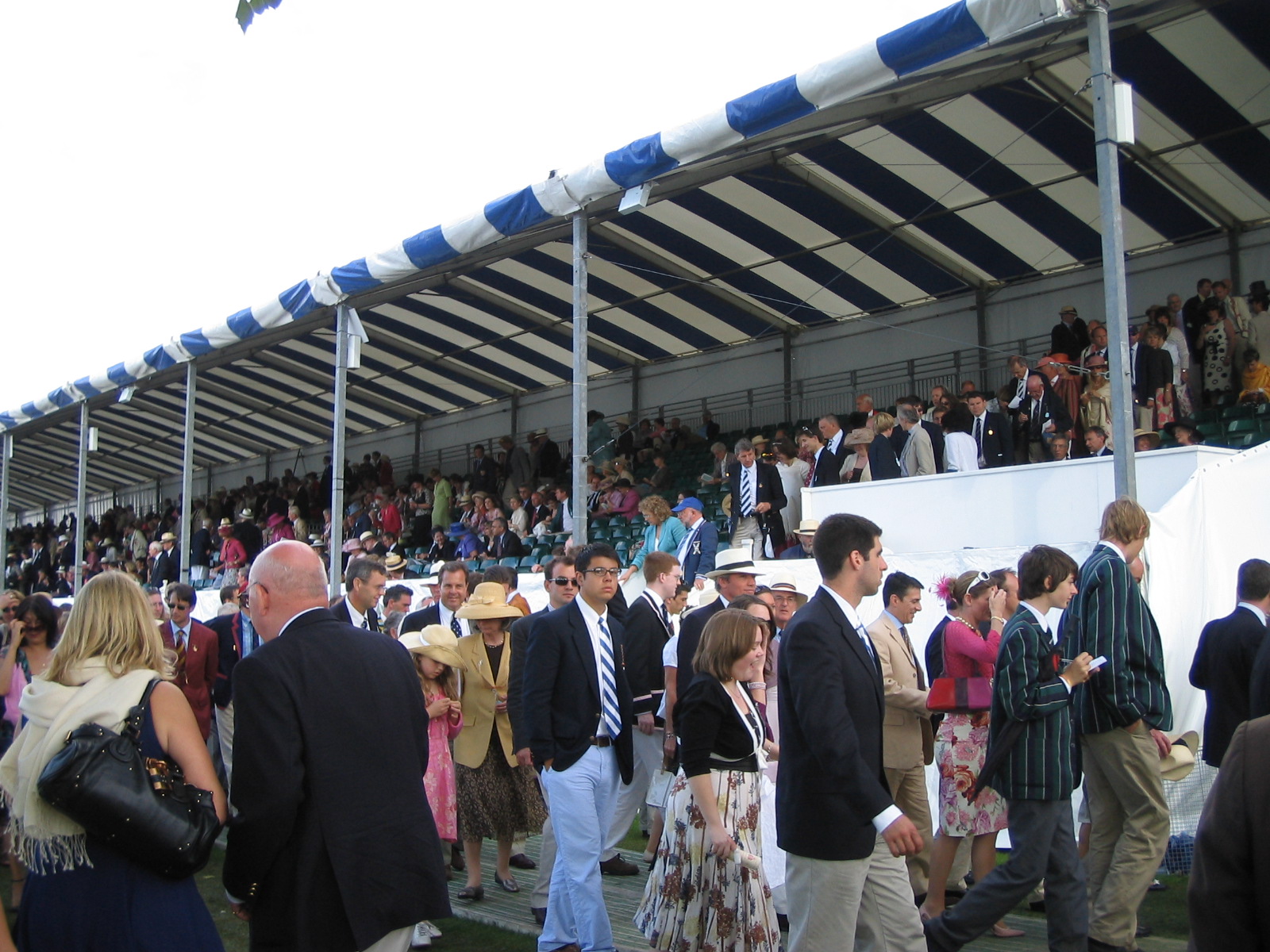 a crowd of people standing around at a tennis game