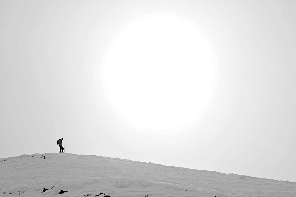 the man is hiking up a snowy hill