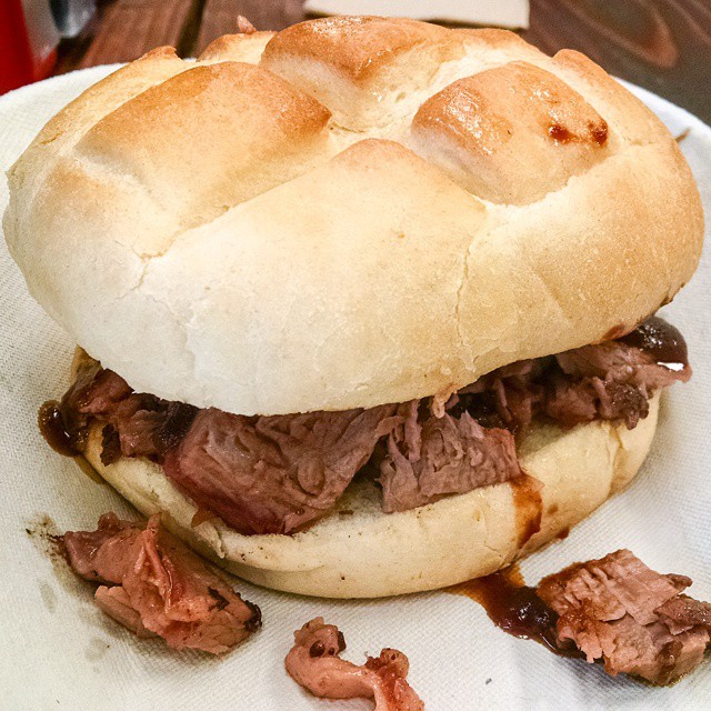 a roast beef sandwich on a plate with  sauce