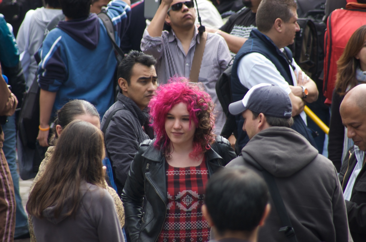 a woman with pink hair in a crowd of people