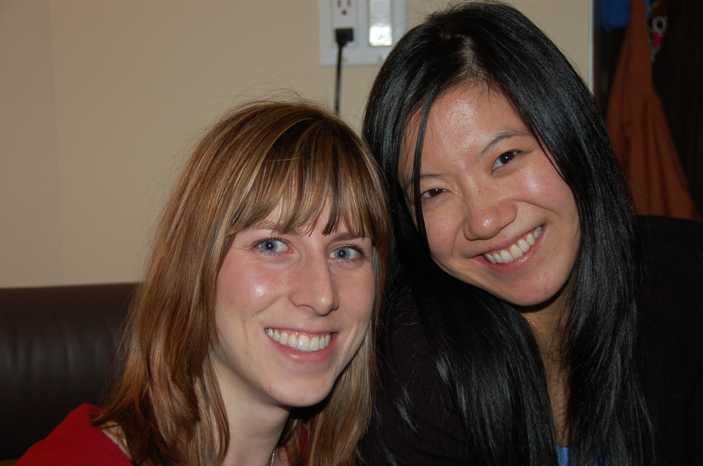 two women posing for the camera while wearing red shirt