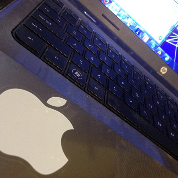 apple logo and keyboard on the back of an open laptop