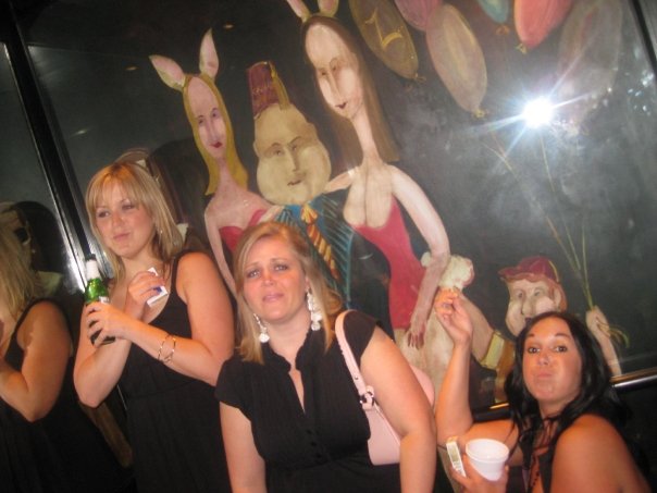 a group of women posing for a po in front of a painting