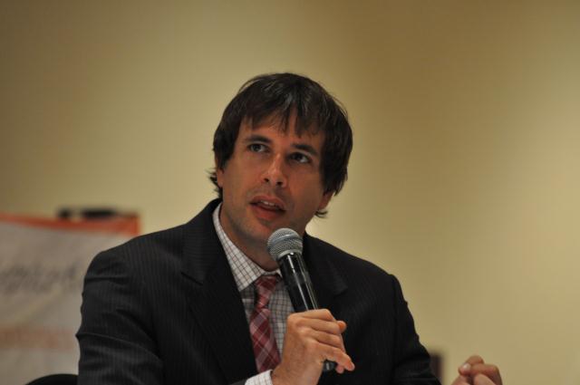 a man sitting in front of a microphone at a meeting