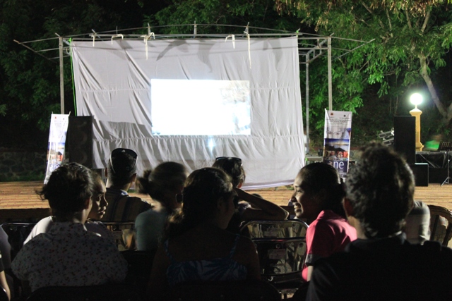 there are many people in the theatre as one gives an interesting performance