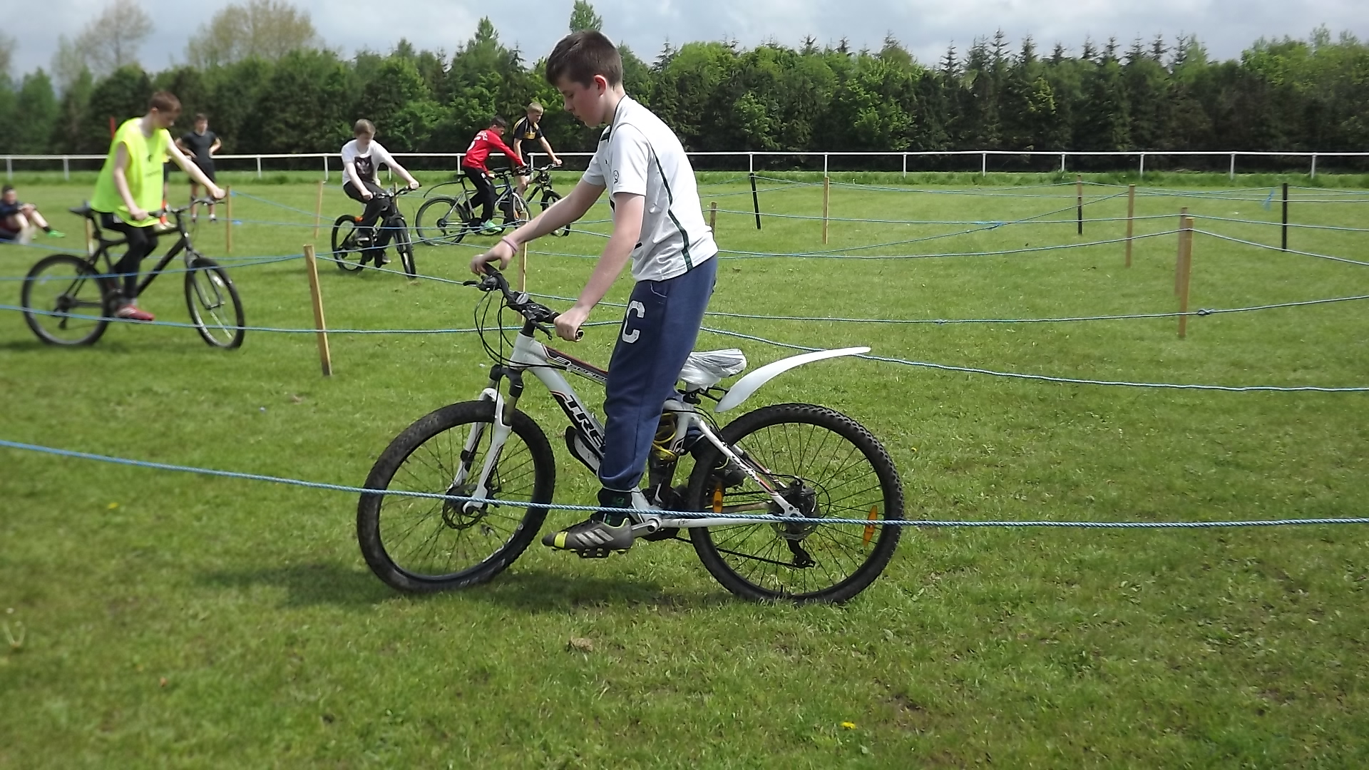 people on bike in grassy area with fence