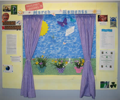 a bulletin board covered in purple curtains and flowers