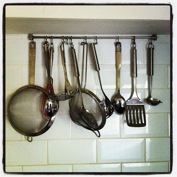 the rack has several cooking utensils on it