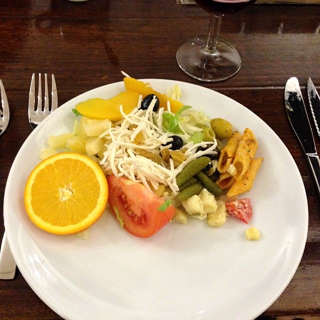 a plate with fruit, salad and some silverware