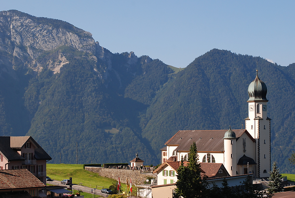 a church on the mountainside with mountains in the background