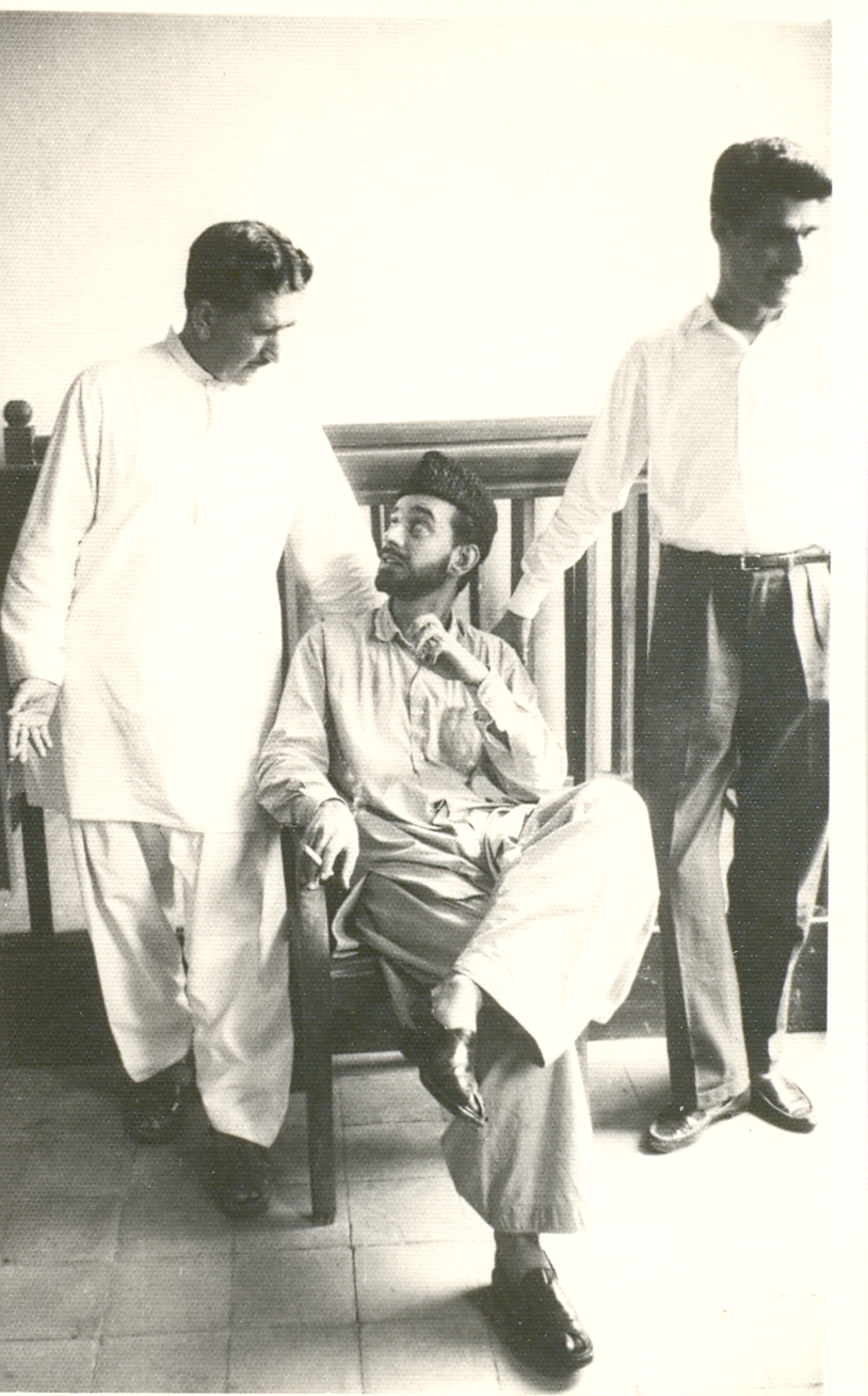 three men standing and talking in a living room