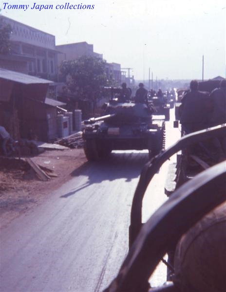 two military vehicles passing each other on the street
