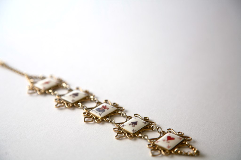 a gold necklace has small glass beads, and some tiny jewels