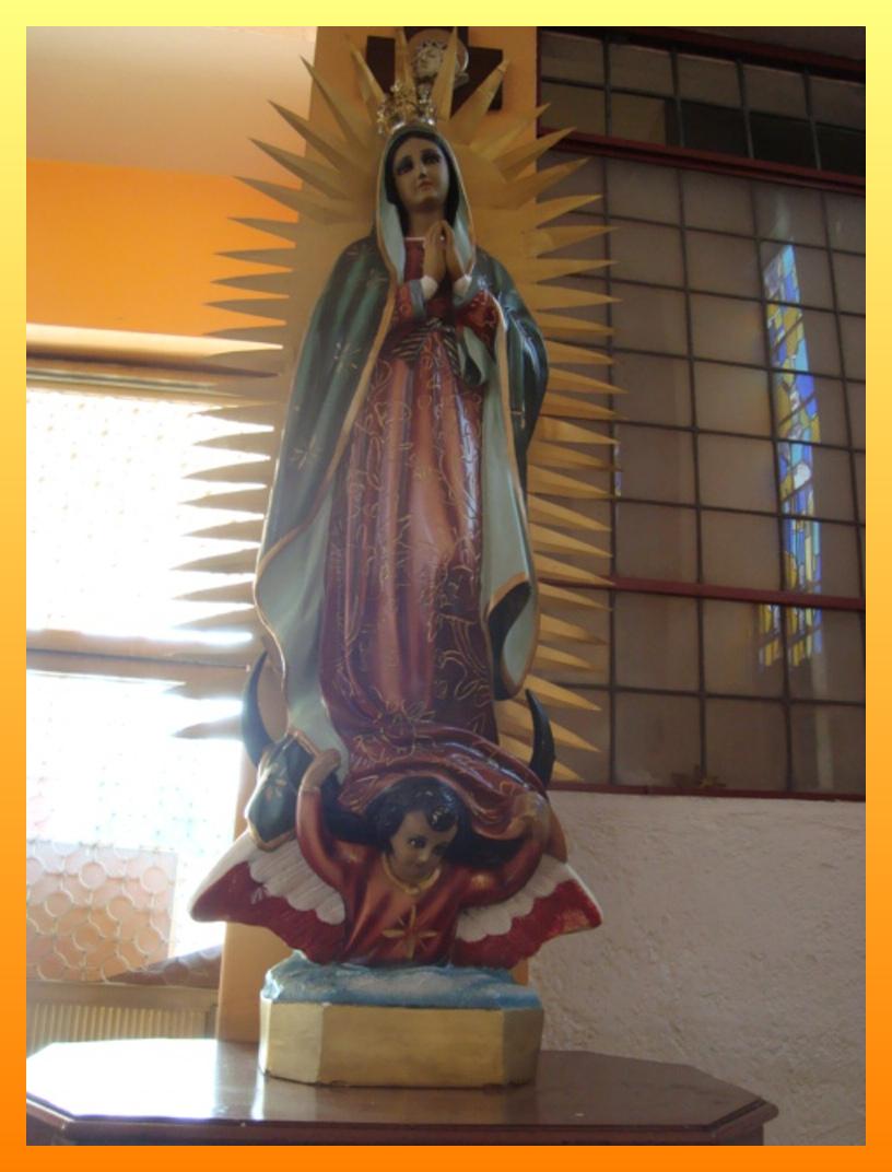 a statue of the virgin mary with a child and an orange background