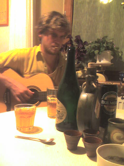 there is a man playing the guitar with glasses and bottles