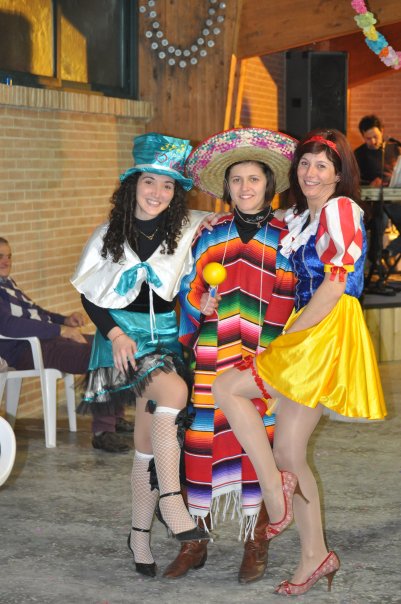 three women dressed up in costumes sitting on chairs