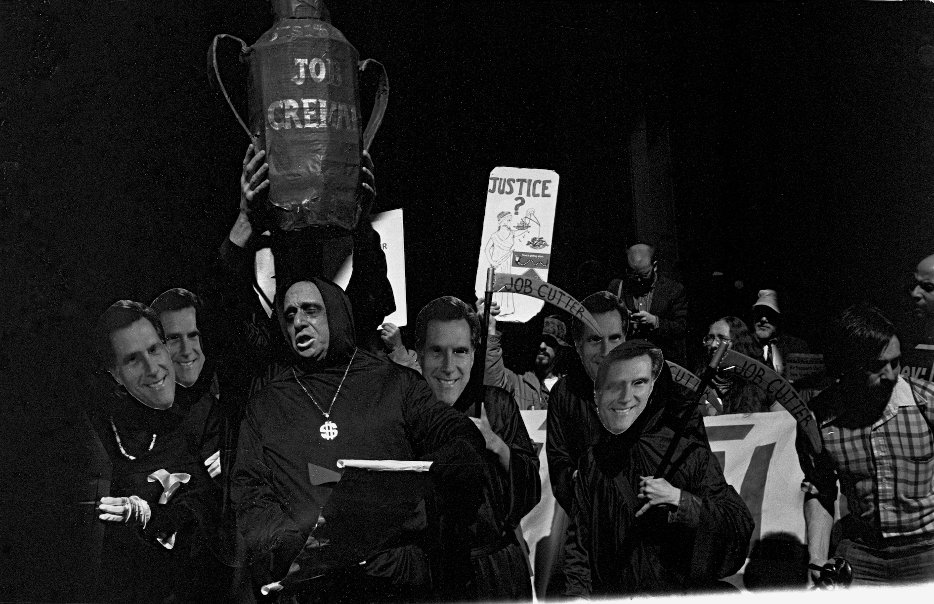 the people stand together and hold up protest signs