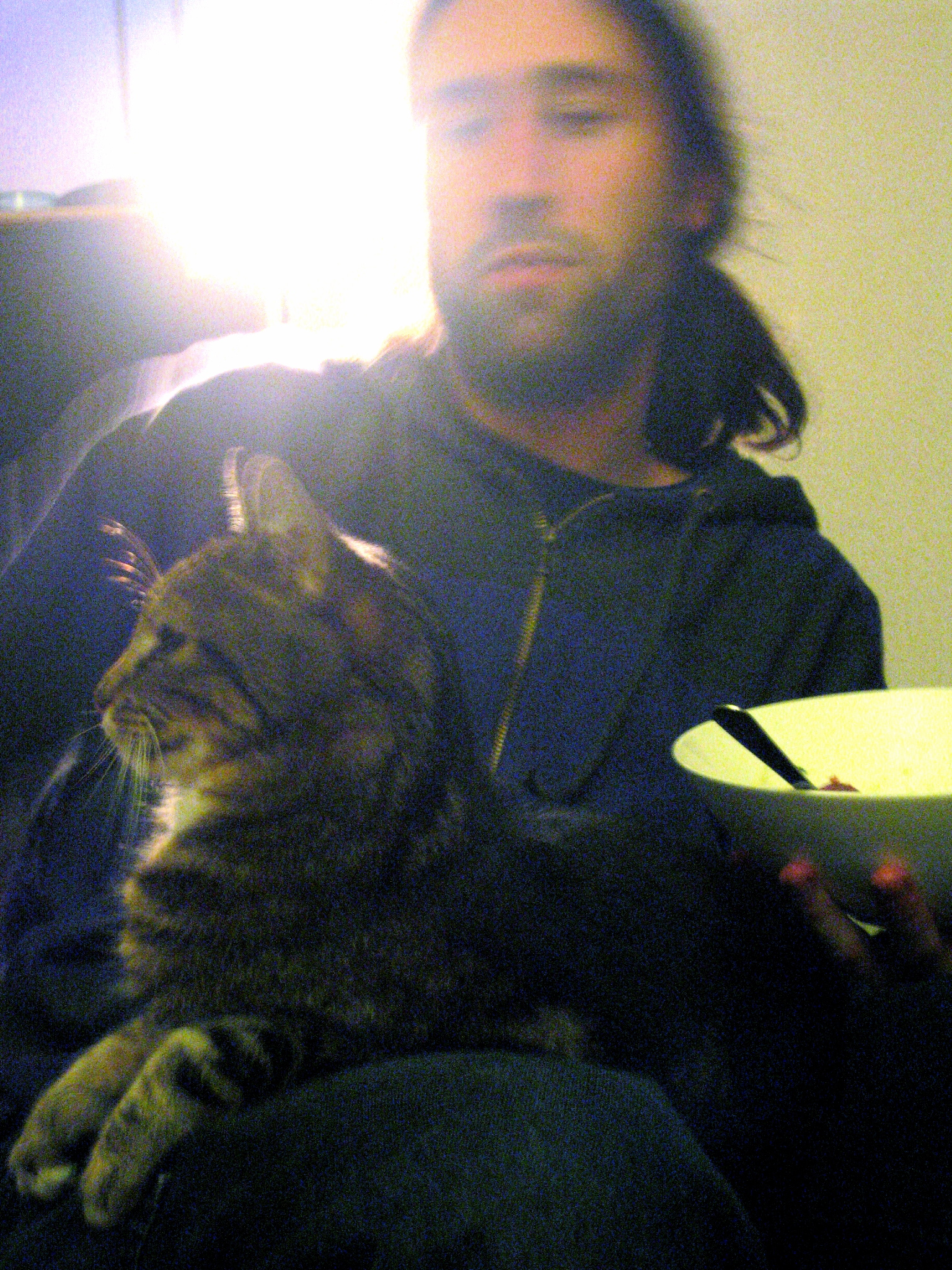 a blurry po of a man sitting with his cat