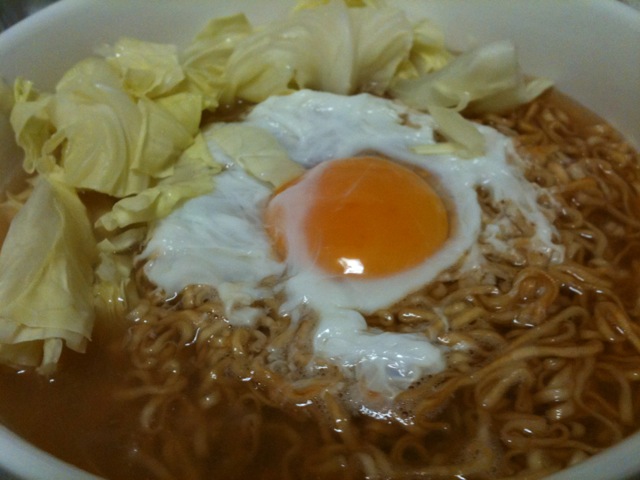 a bowl of noodles and an egg on a plate