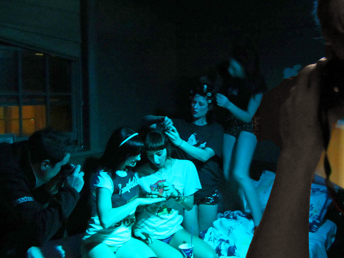 young people sitting on couches in dark room playing with smart devices